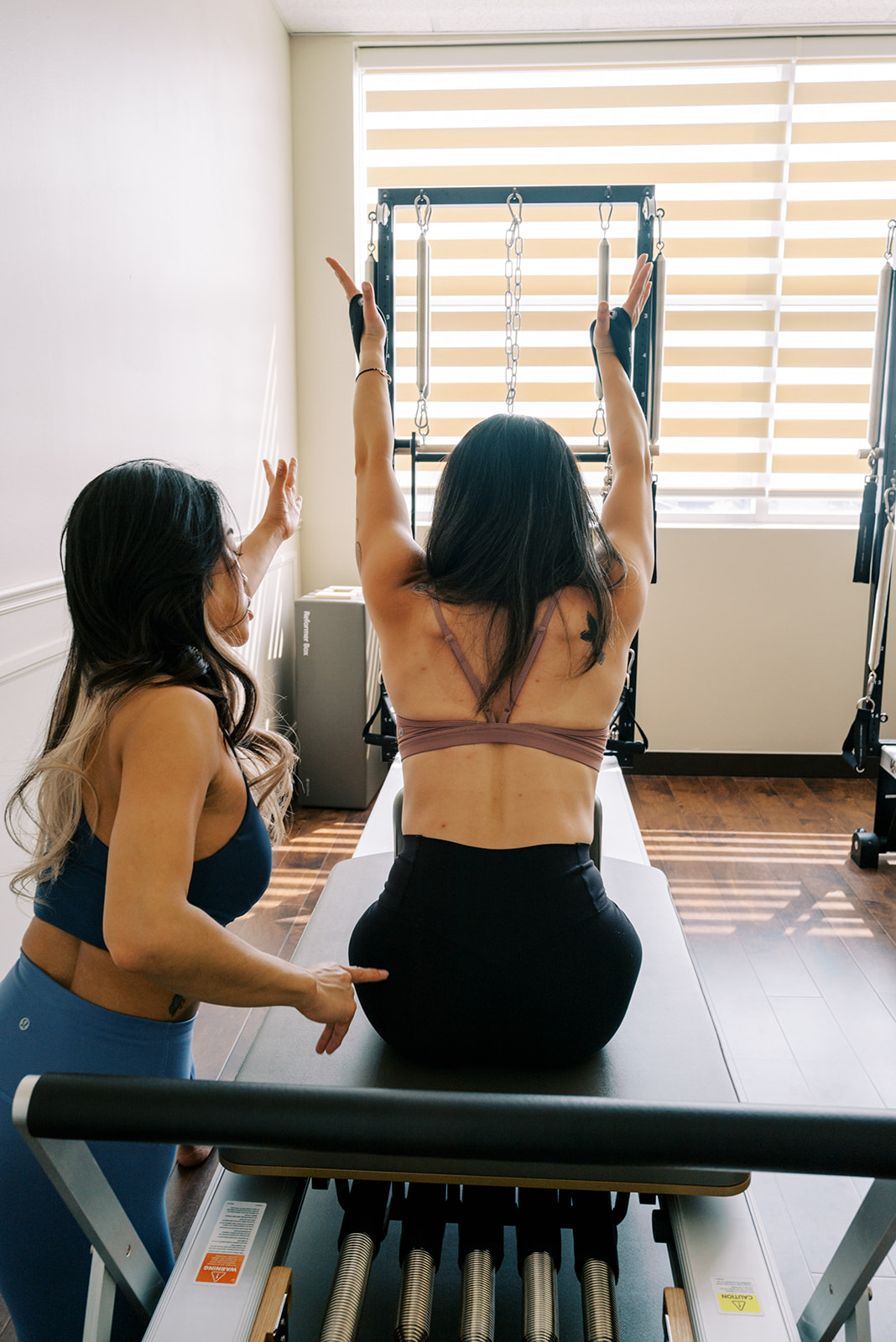 Mi Pilates instructor guiding a client through a reformer session